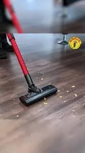 Red vacuum cleaner cleaning a wooden floor