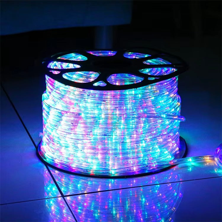 Spool of multicolored LED rope light on a reflective surface